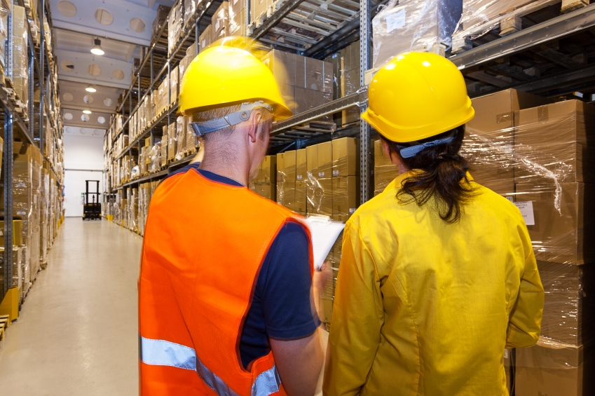 Manager and worker in warehouse with stillage